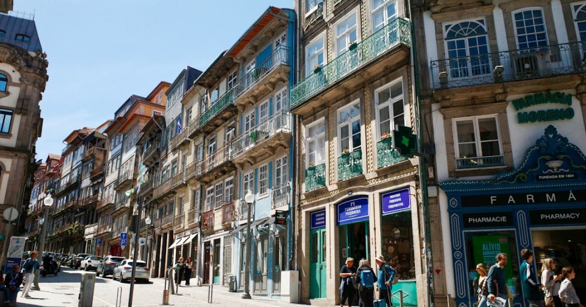Empresário português com expressão preocupada a olhar para um portátil que exibe uma mensagem de "Website Indisponível", com gráficos de falha de servidor ao fundo. Simboliza a frustração com outages de hosts internacionais.